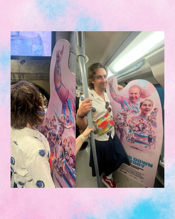 Film poster cutout being carried on a train