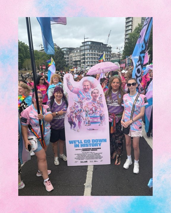Group with a film poster at an outdoor parade