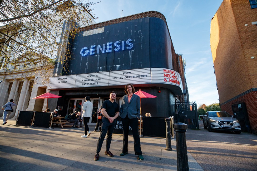 Two people outside a cinema in the evening