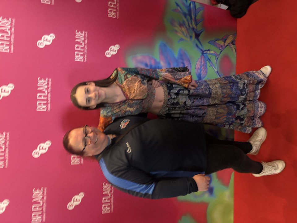 Two people at a festival photo wall