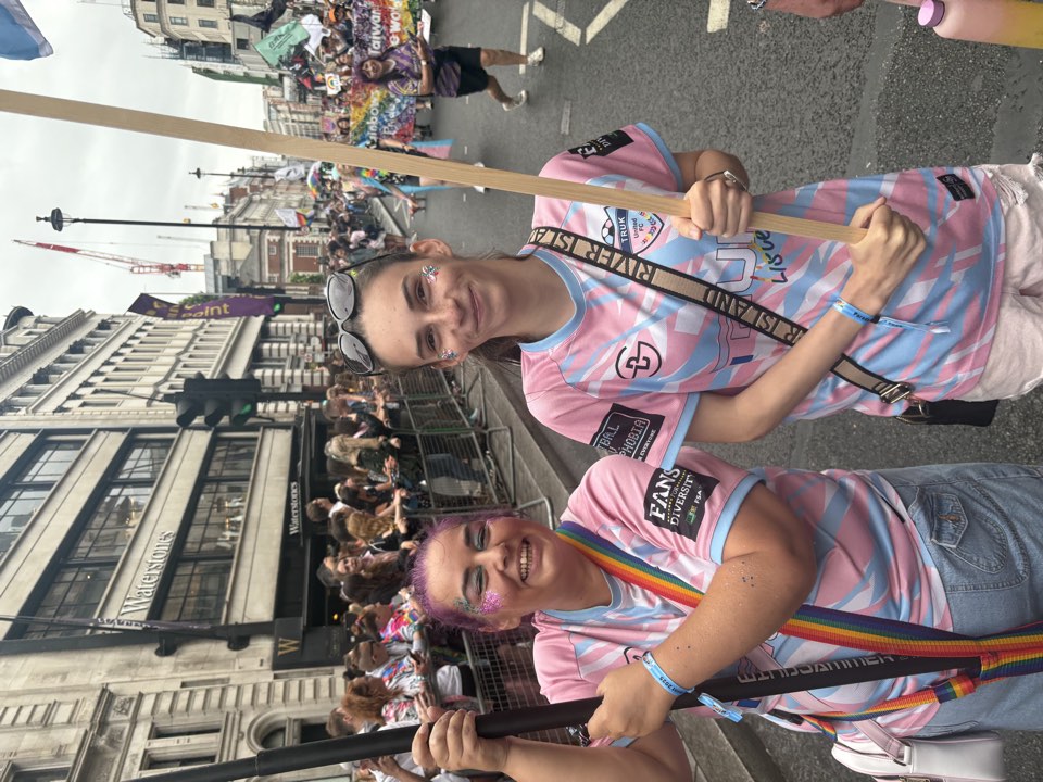 Two people carrying a film poster at a parade