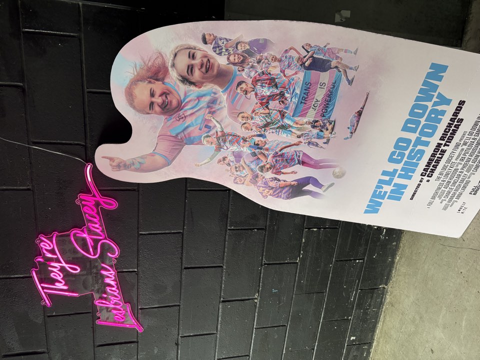 Guitar-shaped film poster cutout at a venue