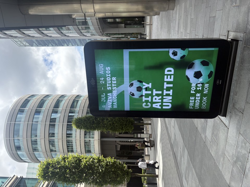 Tablet showing football artwork in a city square